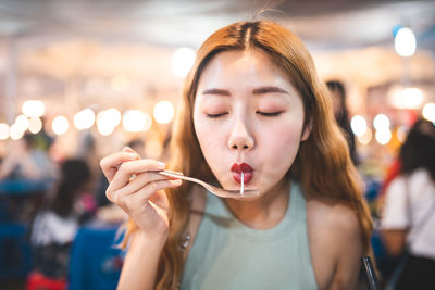 Young woman eating in restaurant