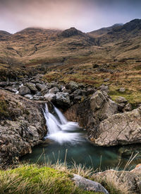 Scenic view of waterfall against sky
