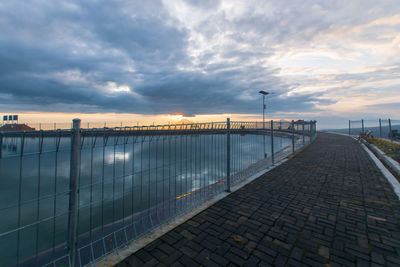 Bridge over river against sky during sunset