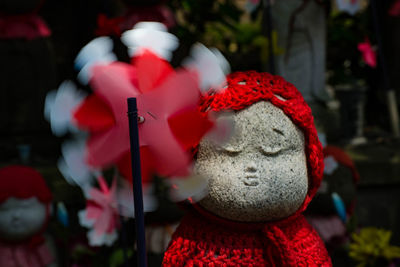 Close-up of spinning pinwheel against statues