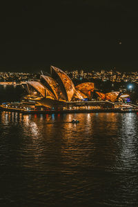 Illuminated bridge over river at night