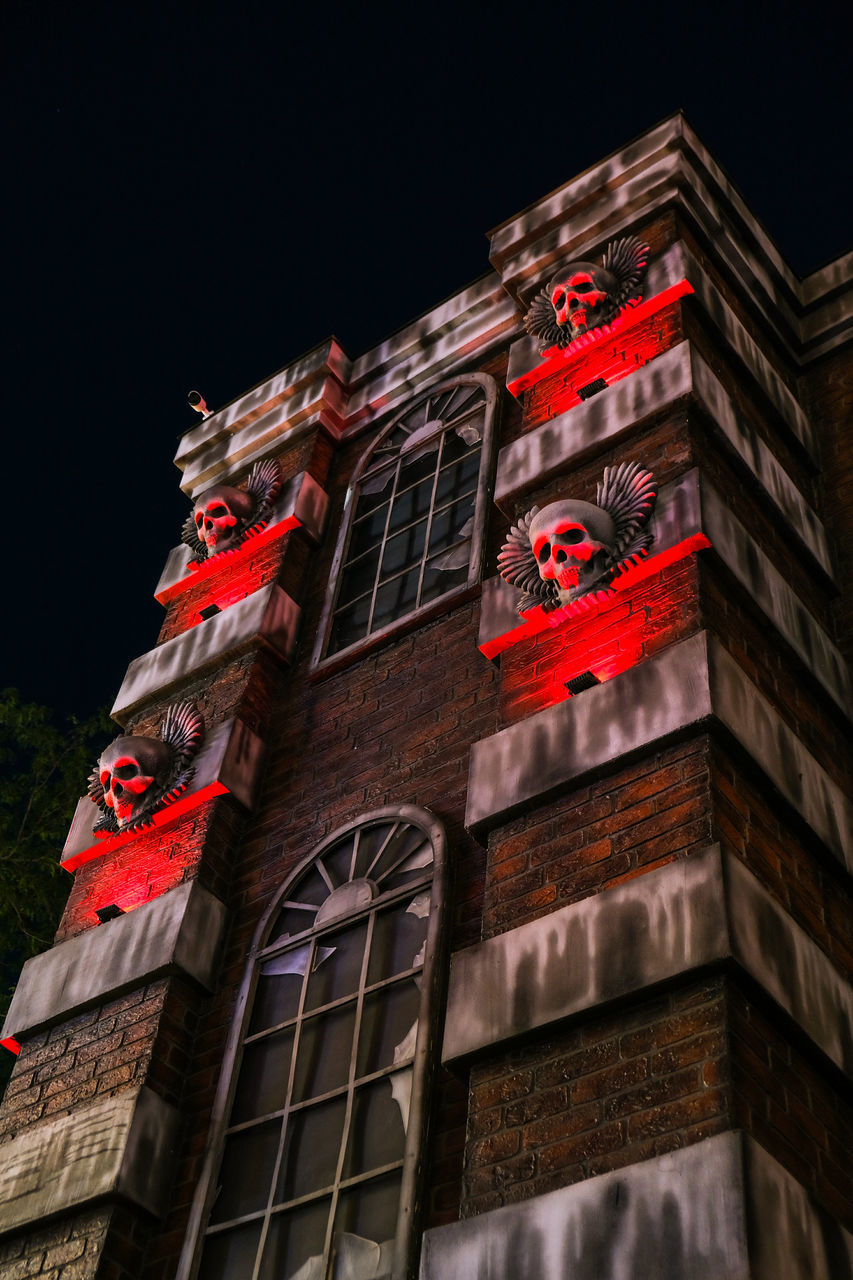 LOW ANGLE VIEW OF ILLUMINATED BUILDING AT NIGHT