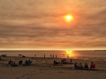 People at beach during sunset