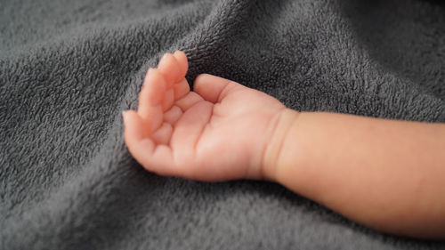 Close-up of baby hand on bed