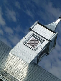 Tilt image of silver tower on roof against sky