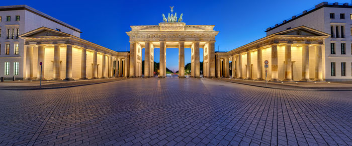 Panorama of the illuminated brandenburg gate in berlin after sunset with no people