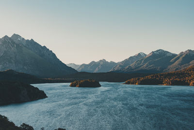 Scenic view of sea and mountains against clear sky