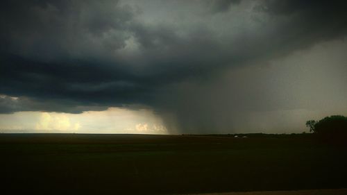 Scenic view of storm clouds over field