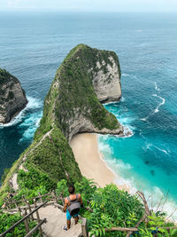 High angle view of shirtless man standing on steps against sea