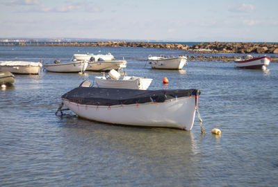 Boats moored in sea against sky