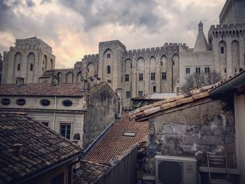 Buildings in city against cloudy sky