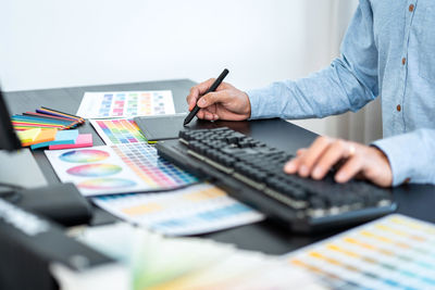 Midsection of businessman working on table