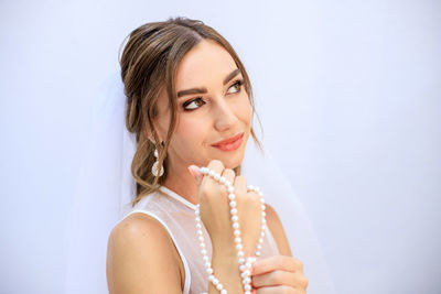 Portrait of a smiling young woman over white background