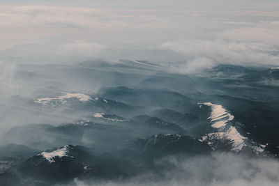 Aerial view of mountains against cloudy sky