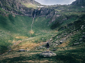 Rear view of person standing on rock