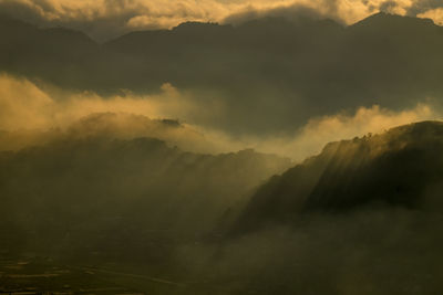 Scenic view of mountains against storm clouds