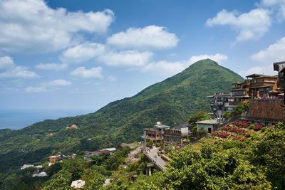 Scenic view of town by sea against sky