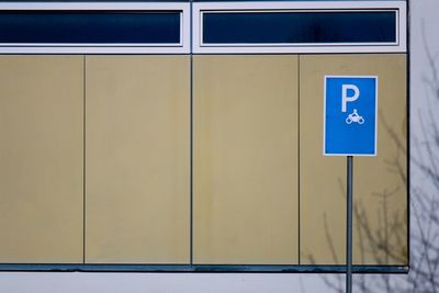 Close-up of information sign against billboard