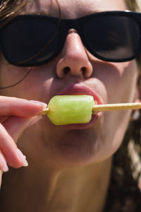 Close up of a woman eating a green ice lolly