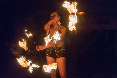 Young woman performing with fire at night