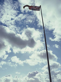 Low angle view of crane against cloudy sky