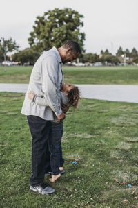 Happy father and son embracing outside at park at dusk