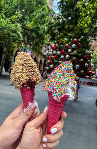 Cropped hand of woman holding christmas tree