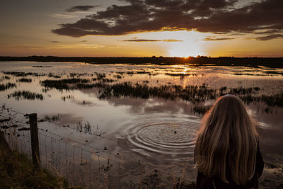 Rear view of woman at sunset