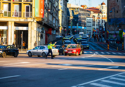 Vehicles on road by buildings in city