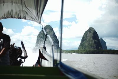 Panoramic shot of sea by mountains against sky