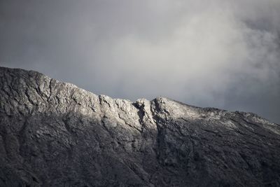 Low angle view of rocky mountain against sky