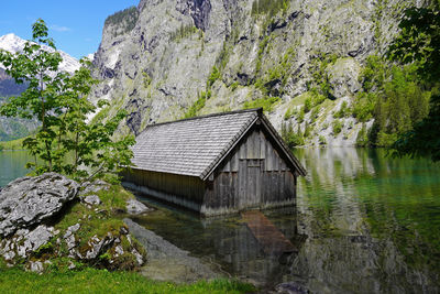 House by lake and building against sky