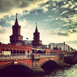 Bridge over river against cloudy sky