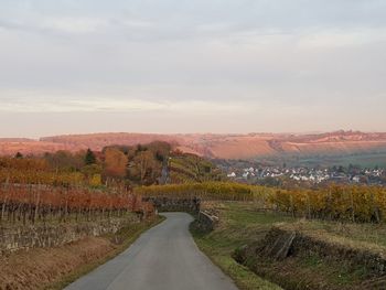 Empty road along landscape and against sky