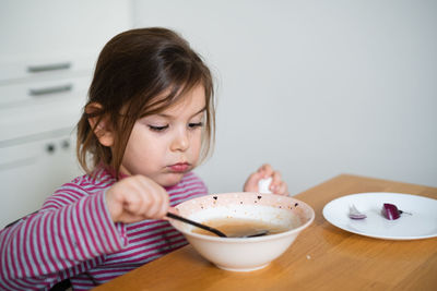 Close-up of boy eating food on table