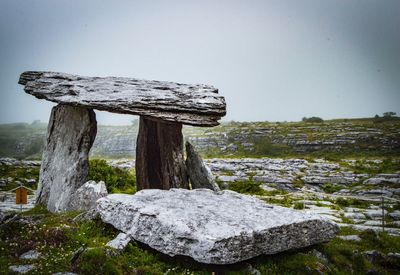 Close-up of wooden post on tree stump against sky