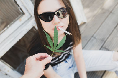 Cropped hand holding marijuana by young woman