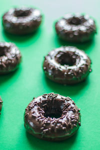 Close-up of chocolate donuts on green background