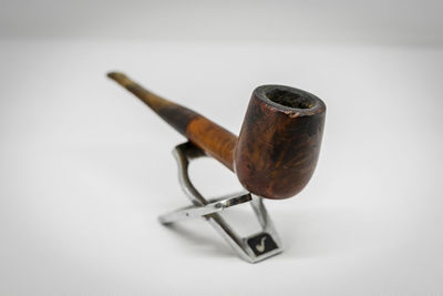 Close-up of cigarette on table against white background