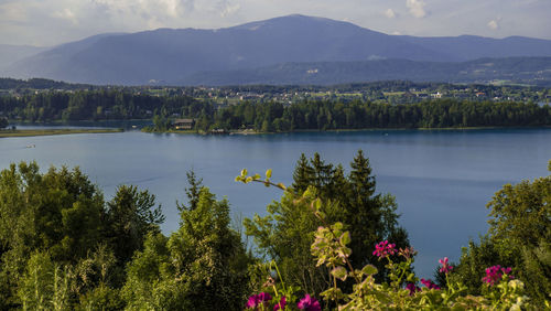 Scenic view of lake by mountains against sky