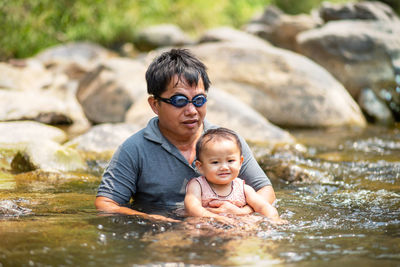 Mature man with granddaughter in lake