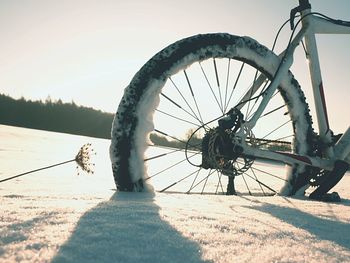 Close-up of bicycle wheel on field against sky