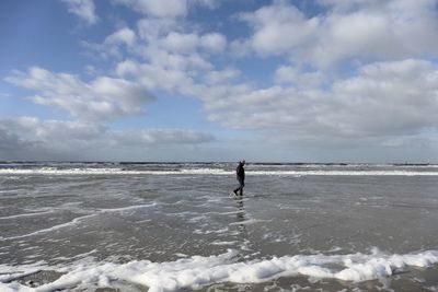 Man surfing in sea against sky