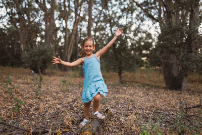Portrait of happy girl playing in forest