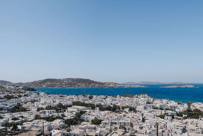 Aerial view of town by sea against clear sky