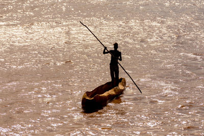 Silhouette man fishing in sea