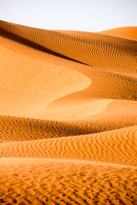 Sand dune in desert against clear sky