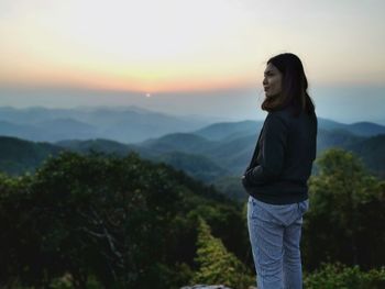 Man standing on mountain against sky during sunset