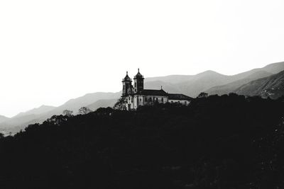 Silhouette of building with mountain range in background