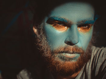 Close-up portrait of serious man with painted face